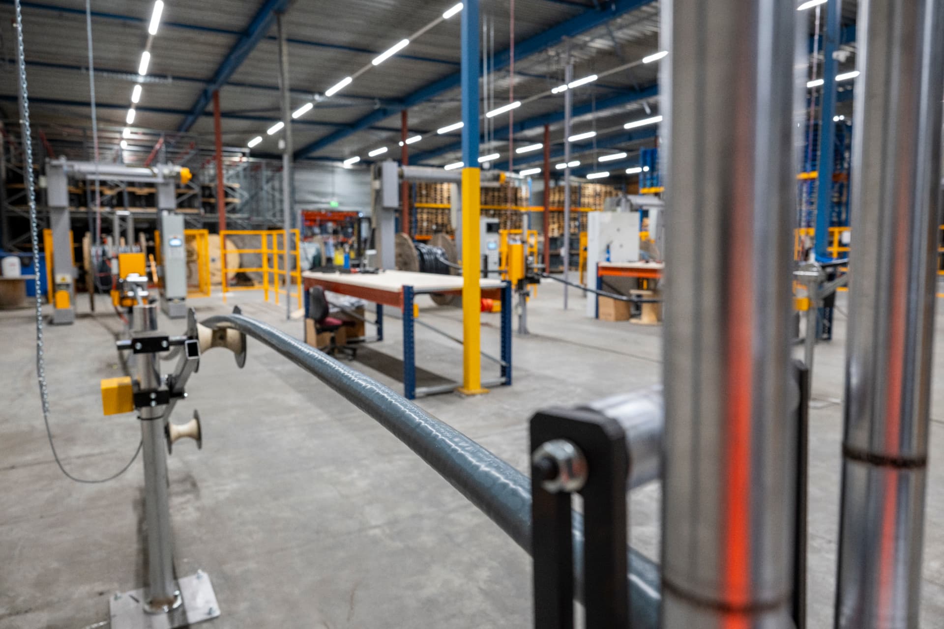 Electrical cable running through rollers on the factory floor